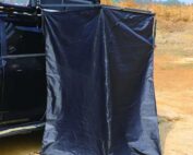 Vestidor portátil DOMINGO instalado junto al coche, ideal como ducha o cambiador en camping